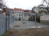 Staví přístřešek pro vozy mětského úřadu za novou budovou u řeky Balinky.
