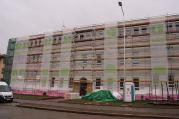 Školu na Sokolovské už zakrývá lešení a od spodu už fasádu pokrývá zateplovací polystyren.