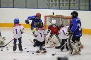 Děti zkouší hokejové dovednosti na týdnu hokeje.