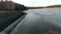 V ledem pokryté přehradě Mostiště je po zimě vody zatím dost.