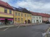 V Komenského ulici opravují střechu, je nutno přejít na protější chodník.