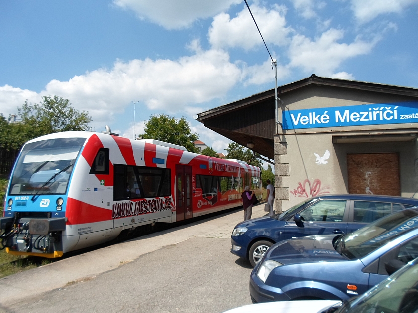 Červený velkomeziříčský vlak na zastávce.