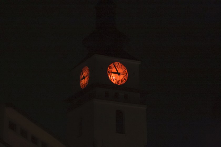Ciferník věžních hodin svítil také červeně.